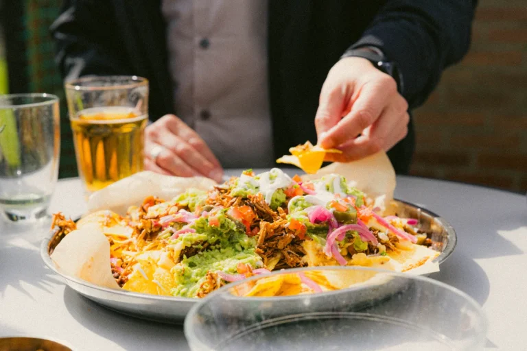 Nacho's aan tafel naast een glas bier